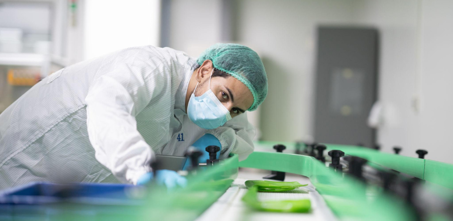 man inspecting assembly line of cosmetics